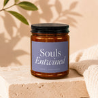 Brown glass candle with a purple label that reads "Souls Entwined" and "Vowed | Hand Poured".