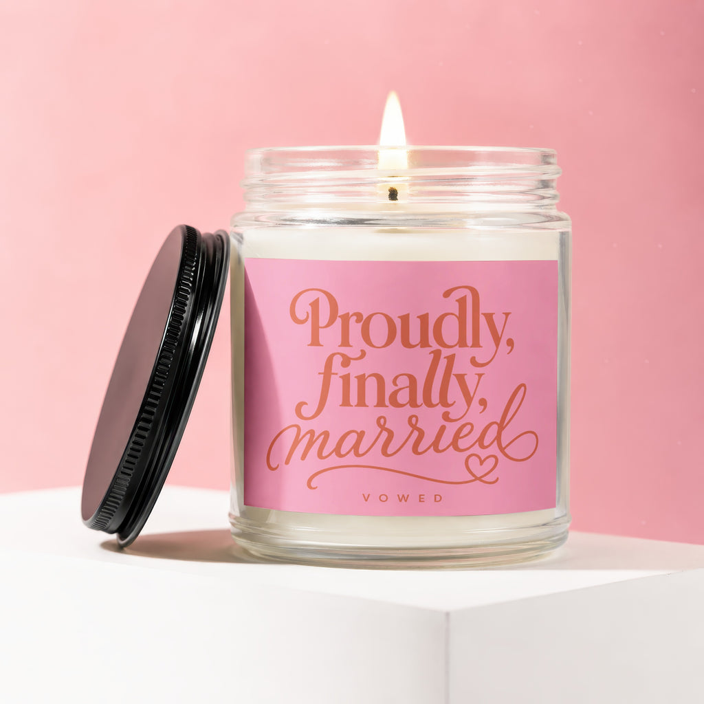 Glass candle with pink label that reads "Proudly, finally, married" and "VOWED".