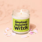 Candle with text "Skeptical Honorary Witch" on a light green label.