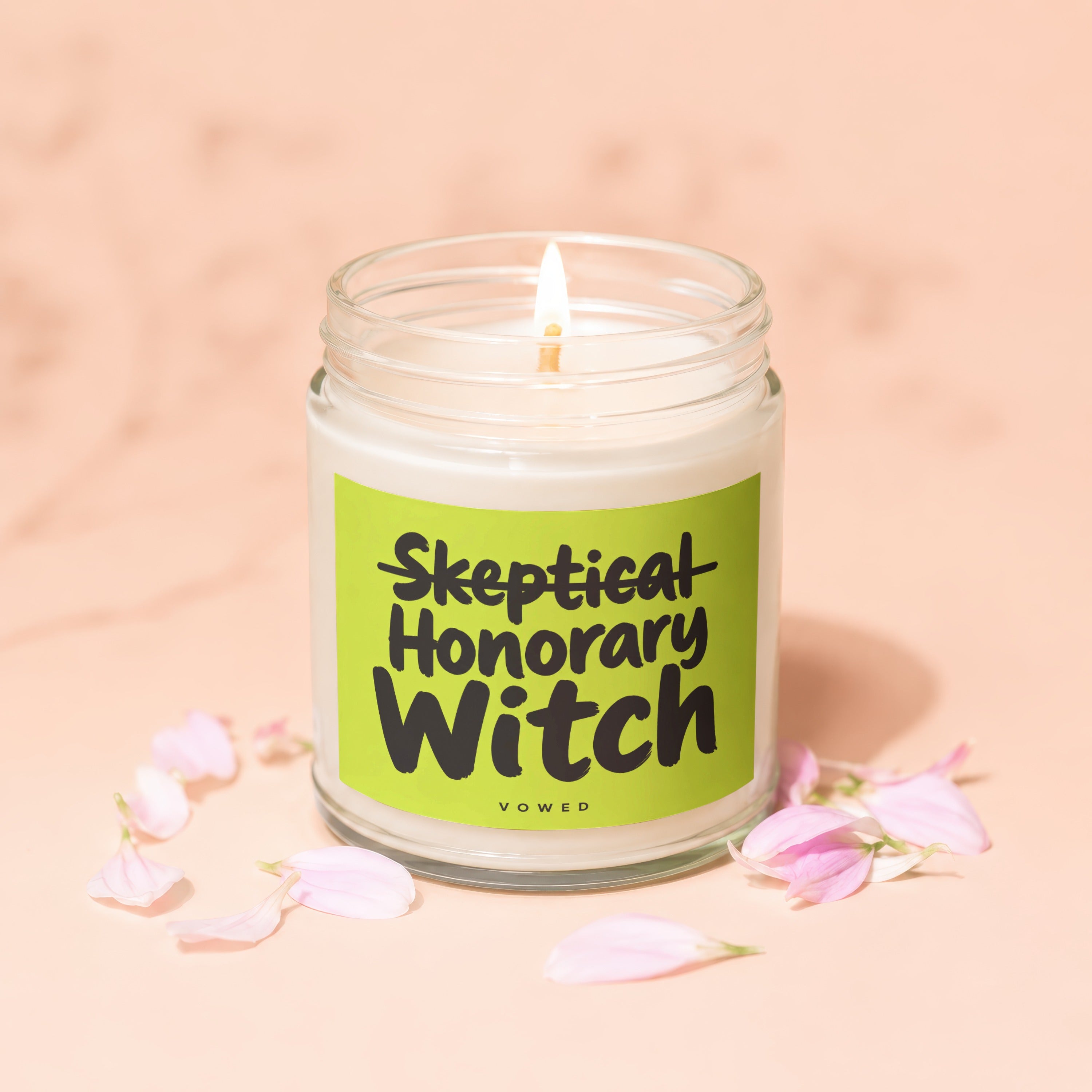Candle with text "Skeptical Honorary Witch" on a light green label.