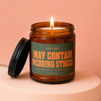 Amber jar candle with green label reading "CAUTION: MAY CONTAIN WEDDING STRESS".
