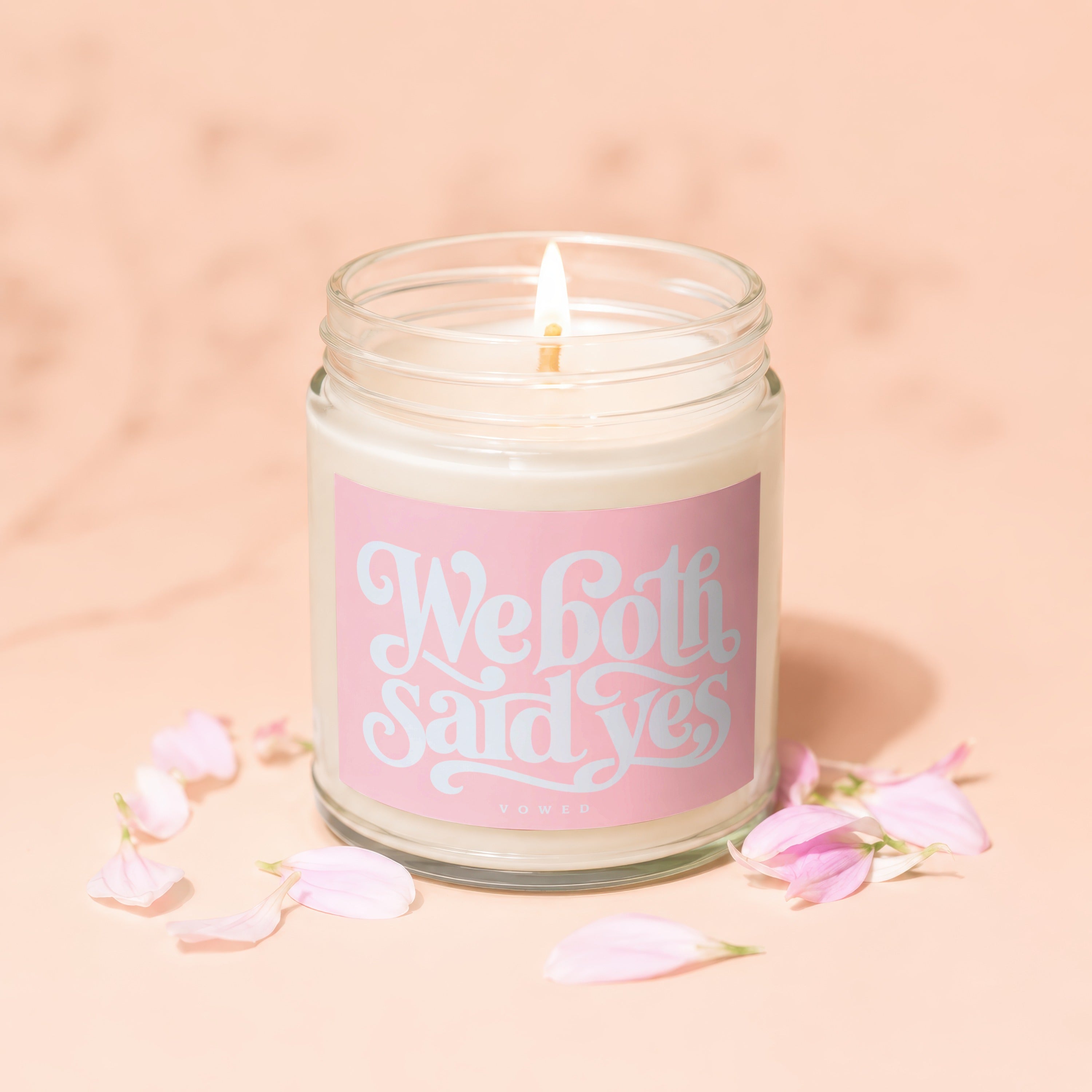 Lit candle in a jar with a pink label that reads "We both said yes"