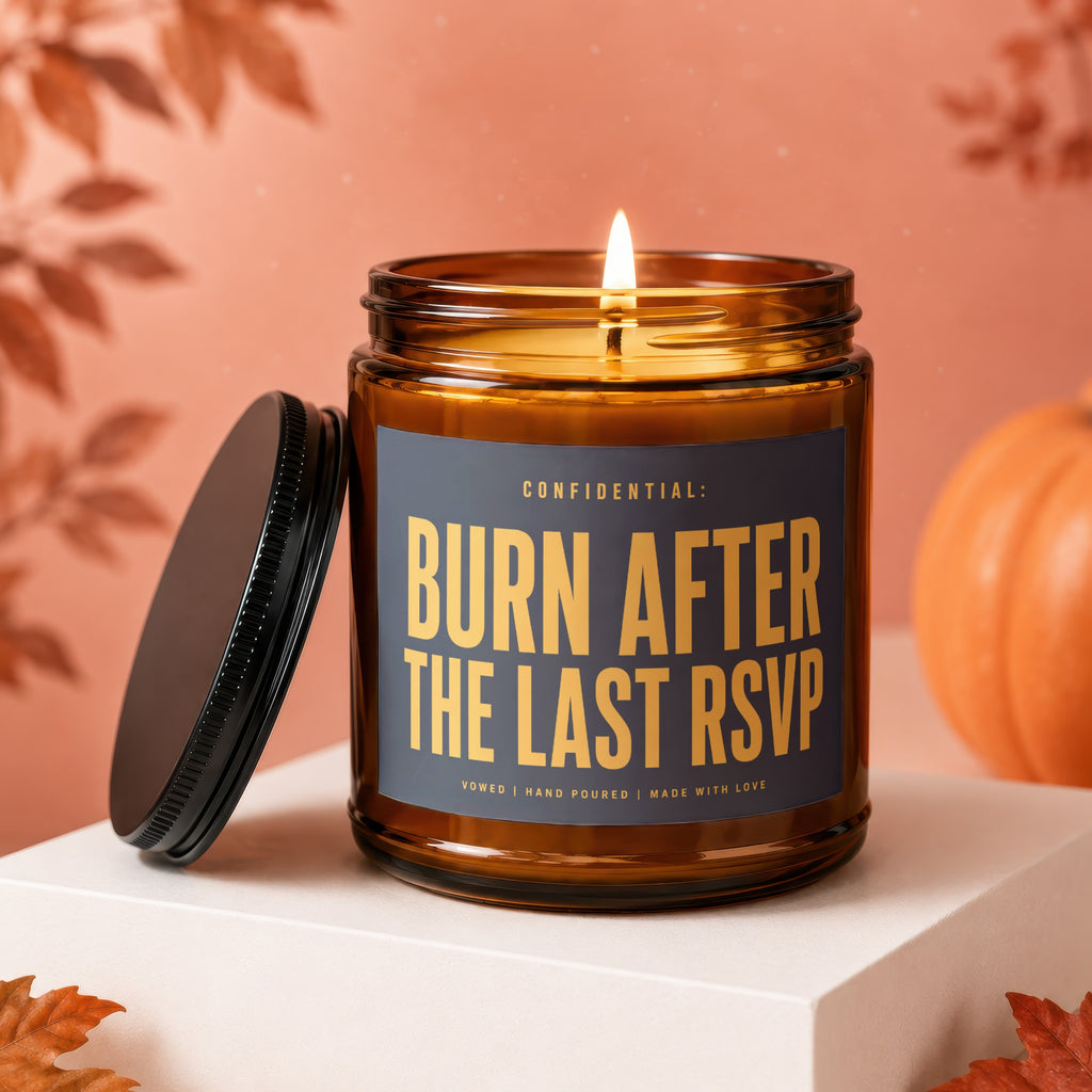 Amber candle with lid off, reading "Burn After The Last RSVP".