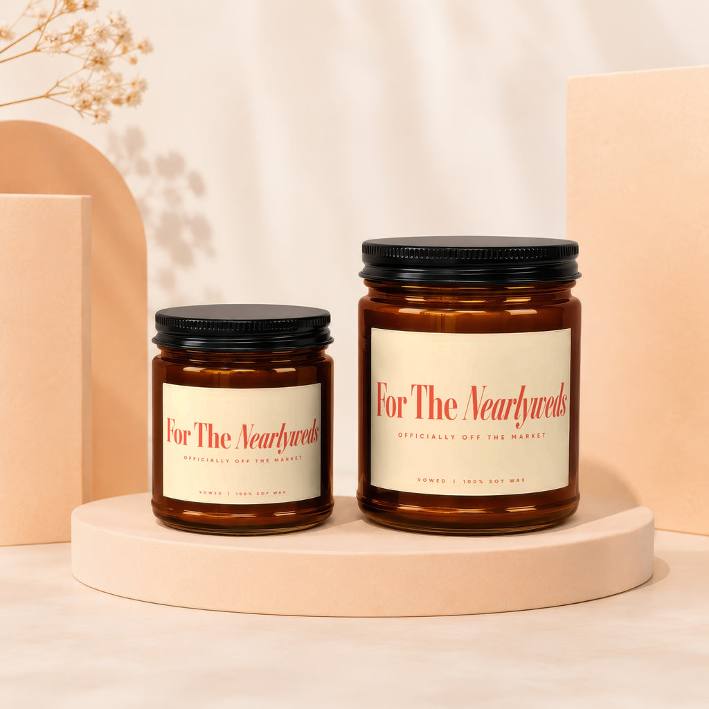 Two amber glass candles, one smaller and one larger, with "For The Nearlyweds" labels.