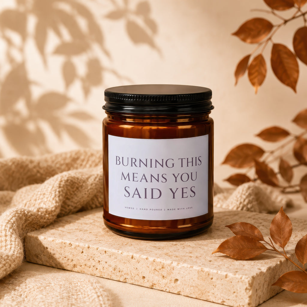 Amber glass candle with black lid reads "Burning This Means You Said Yes".