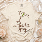 Cream t-shirt with martini glass design and "a tini bit tipsy" text.