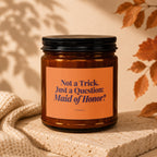 Amber candle with label reading "Not a Trick. Just a Question: Maid of Honor?"