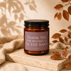 Candle with label "Thank You for Helping Us Tie The Knot Vowed" on stone pedestal.