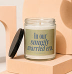 Glass candle with a black lid and label reading "In our smugly married era."