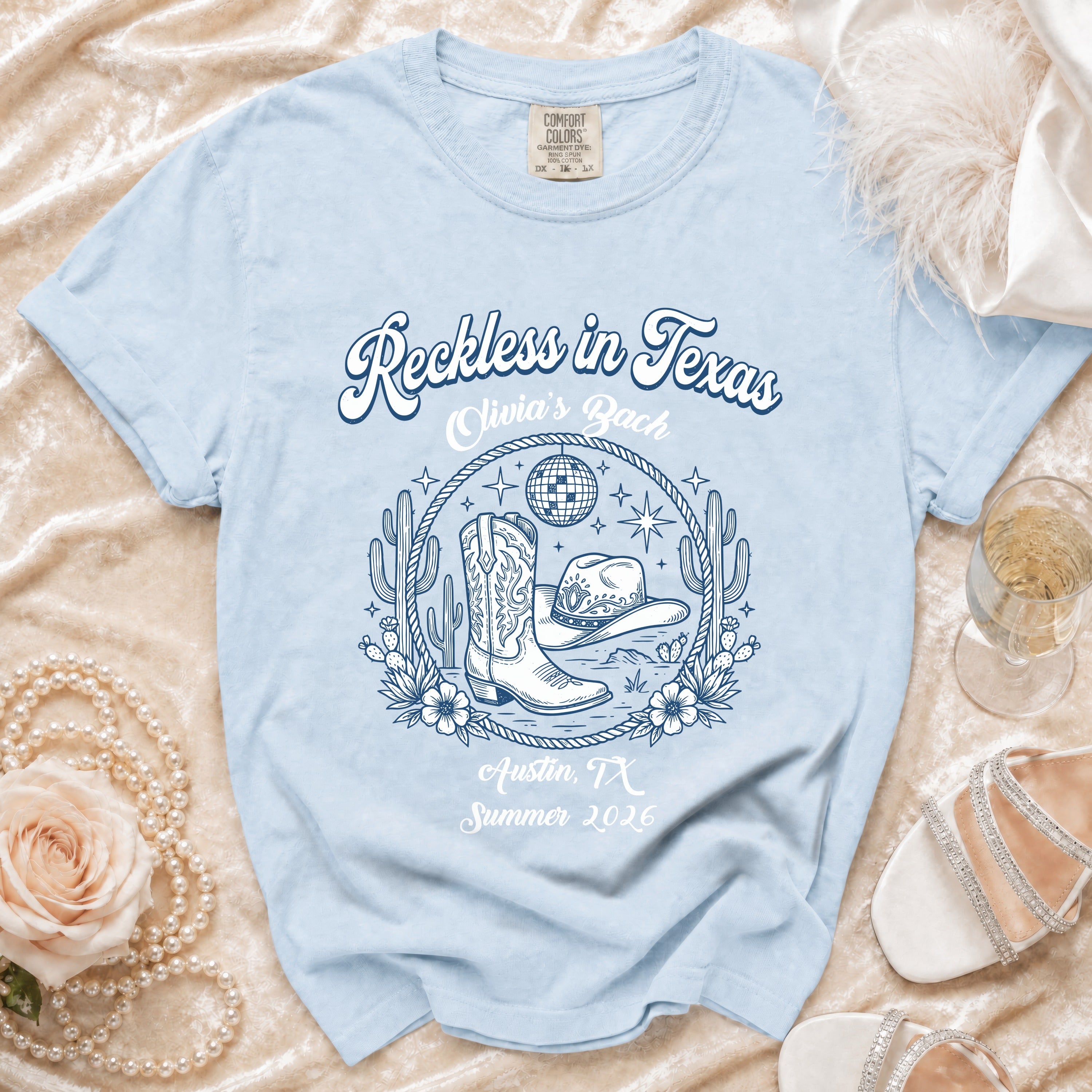Light blue t-shirt with "Reckless in Texas" and Austin, TX Summer 2026 graphic.