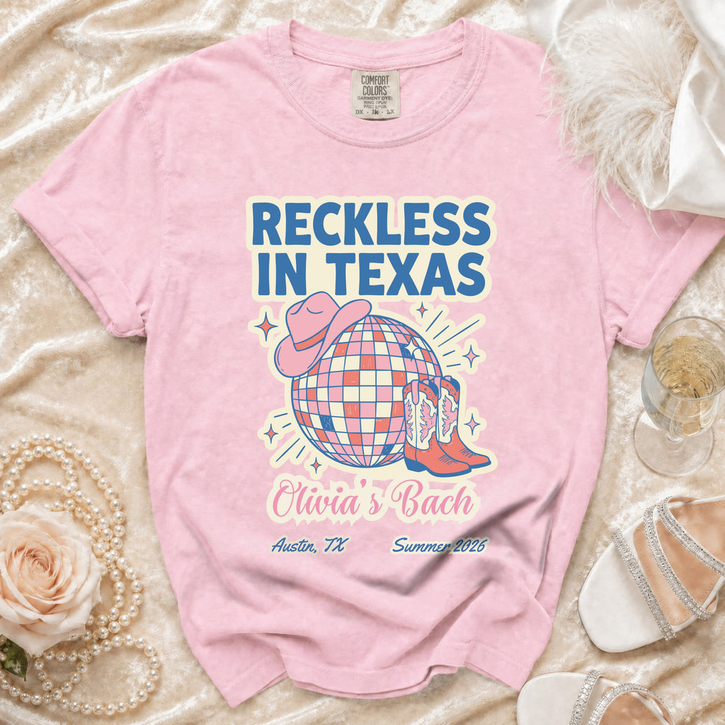 Pink t-shirt with "Reckless in Texas" design, cowboy boots, and disco ball.