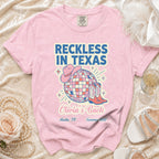 Pink t-shirt with "Reckless in Texas" design, cowboy boots, and disco ball.