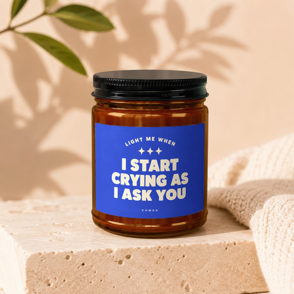 Candle with blue label reading "Light Me When I Start Crying As I Ask You".