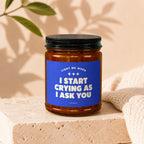 Candle with blue label reading "Light Me When I Start Crying As I Ask You".