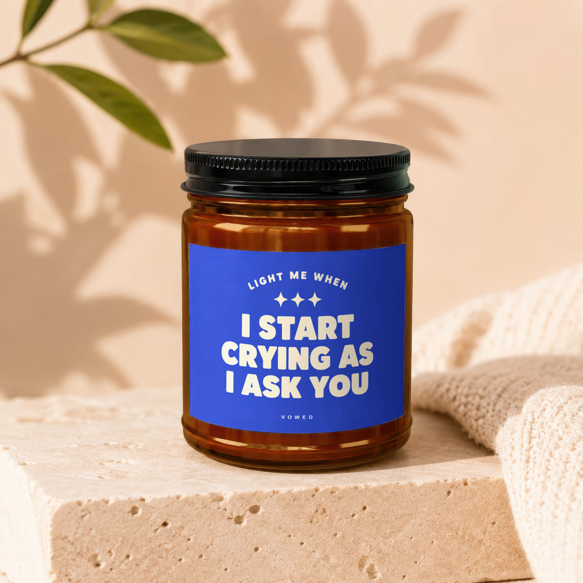 Candle with blue label reading "Light Me When I Start Crying As I Ask You".