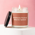 Lit candle in glass jar with "Bachelorette Weekend: Behavior Optional." text on label.