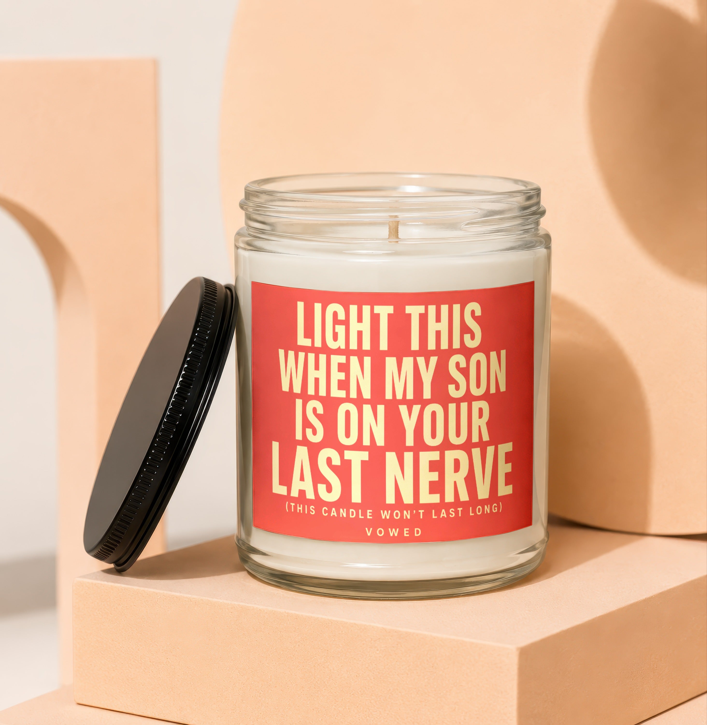 Glass candle with red label reading "Light this when my son is on your last nerve."