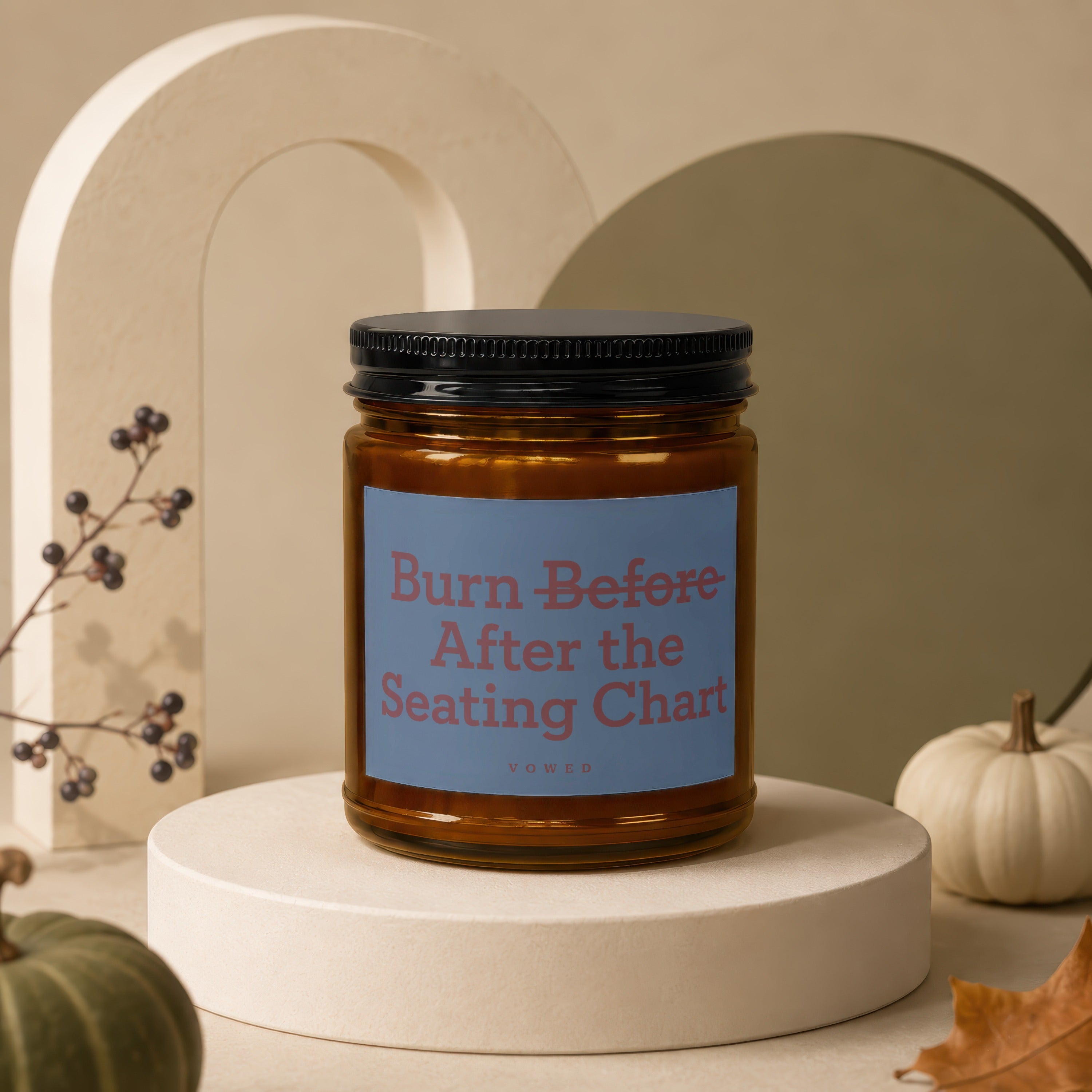 Brown jar candle with black lid, label reads "Burn Before After the Seating Chart".