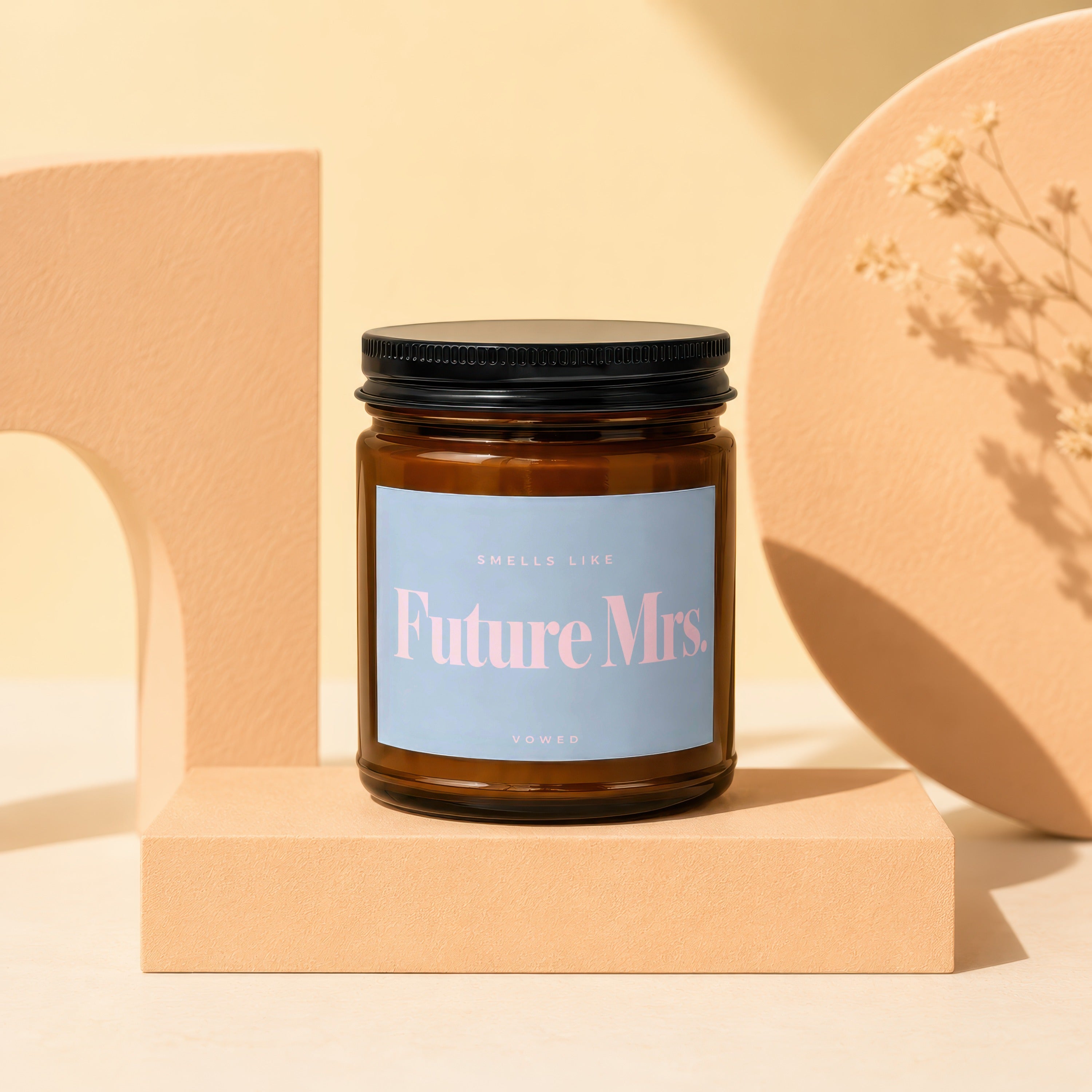 Amber candle with a black lid and a blue label that reads "Future Mrs. Vowed."