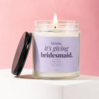 Candle with purple label reading "Sienna, it's giving bridesmaid. say yes?"