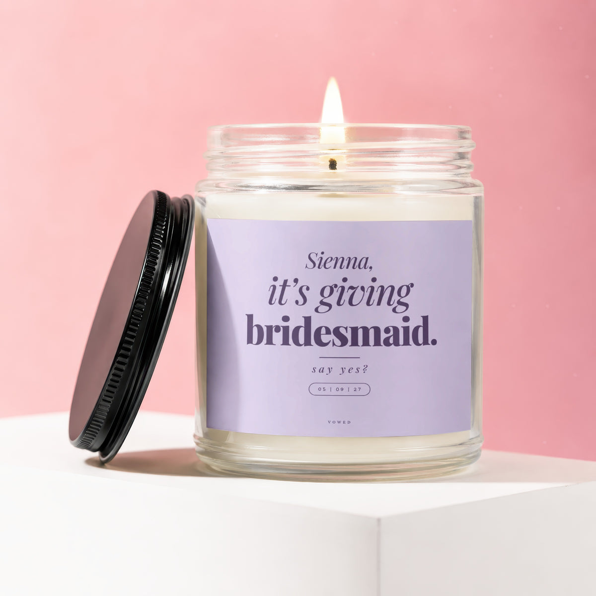 Candle with purple label reading "Sienna, it's giving bridesmaid. say yes?"