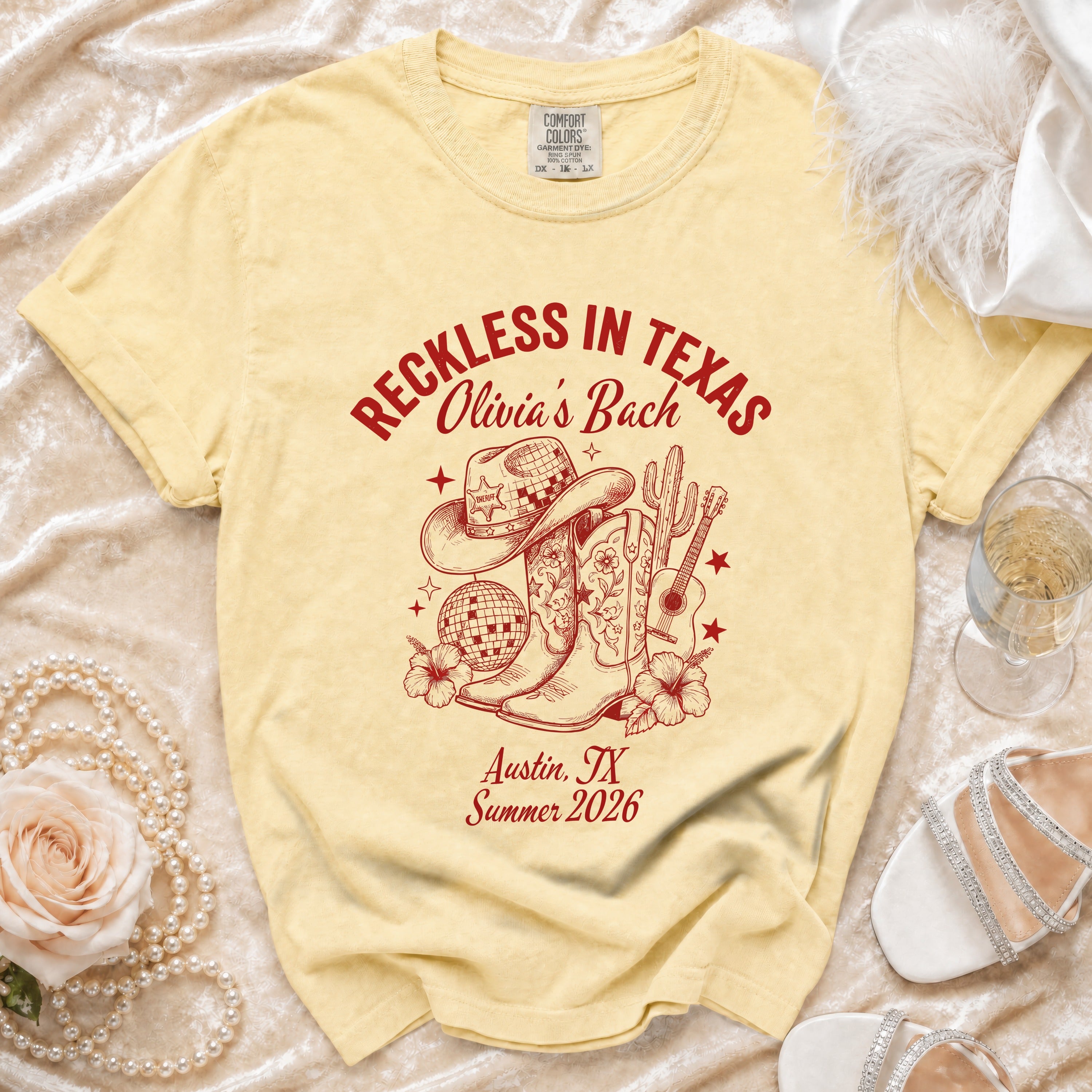 Cream t-shirt with "Reckless in Texas Olivia's Bach" and Texas-themed graphics.