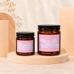 Two amber glass candles with pink labels saying "Two people, one great love".