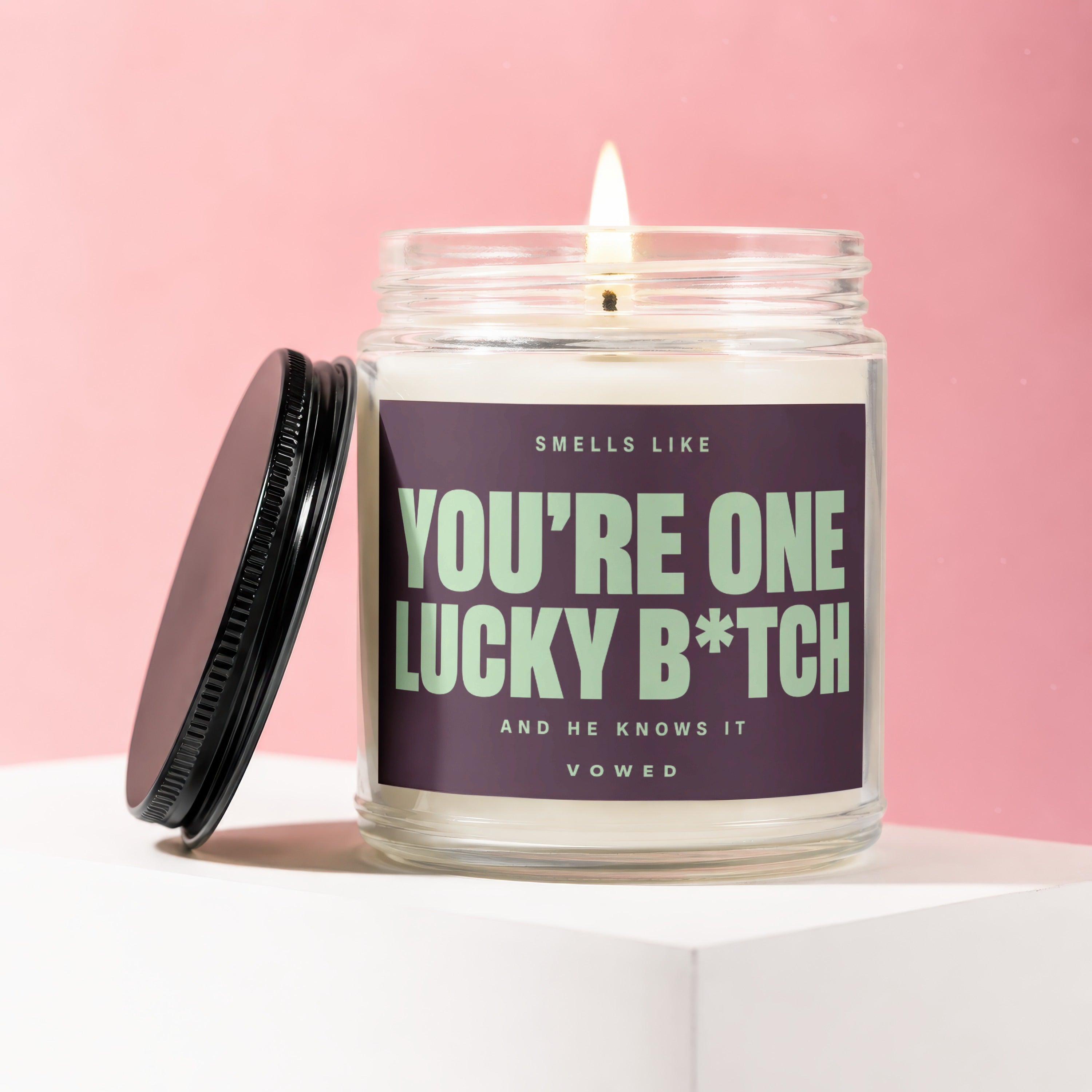 Candle with label reading "Smells like You're One Lucky B*tch. And He Knows It. Vowed."