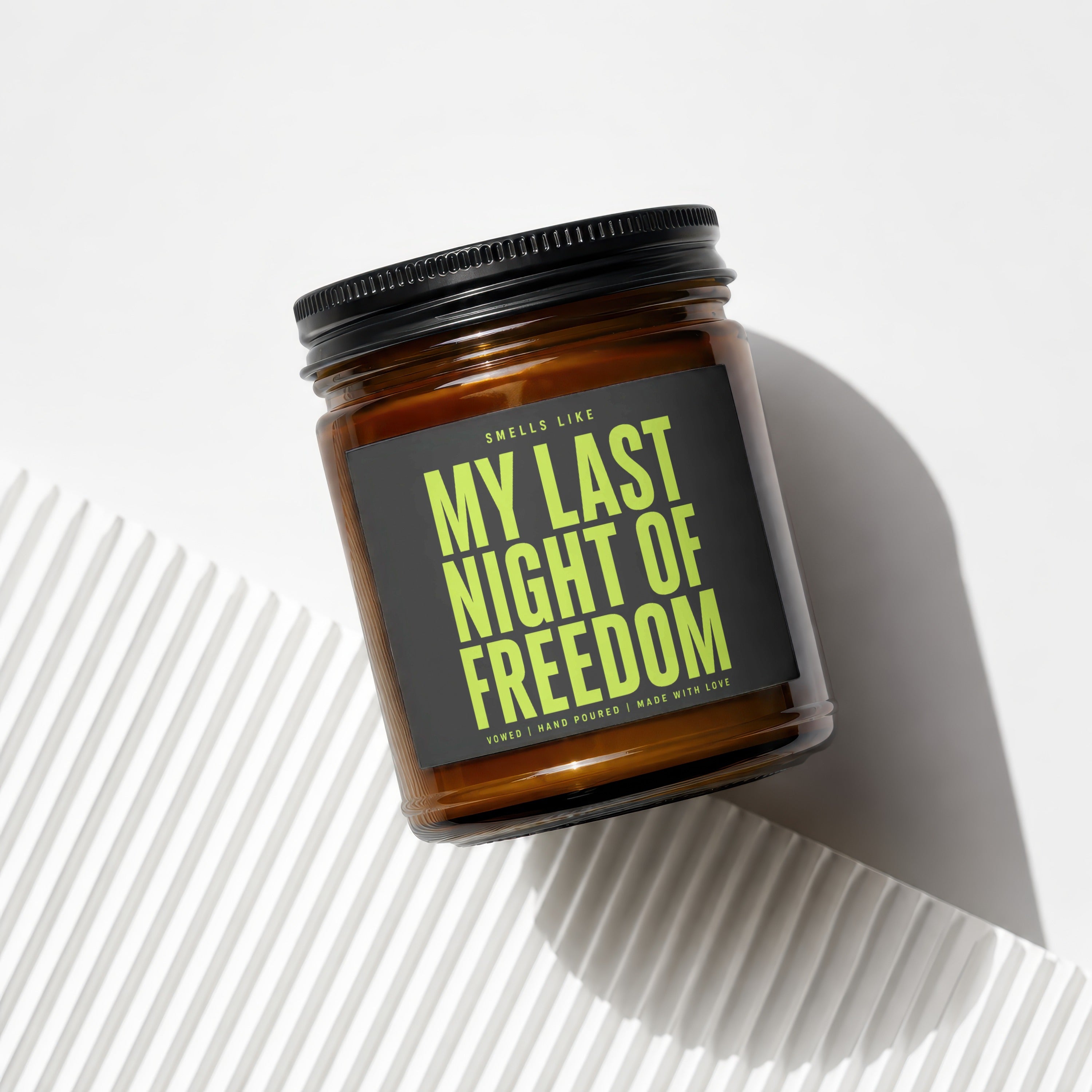Brown amber glass candle with black lid and "My Last Night of Freedom" label.