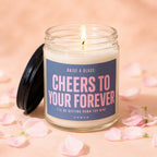 Candle with "Cheers to Your Forever" text and lit flame, surrounded by pink petals.
