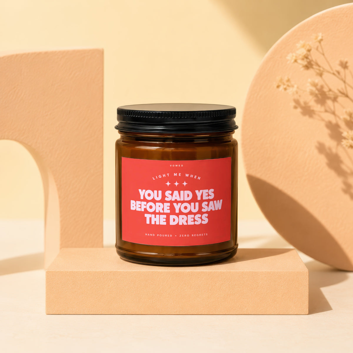 Brown candle with red label that reads "You Said Yes Before You Saw The Dress".