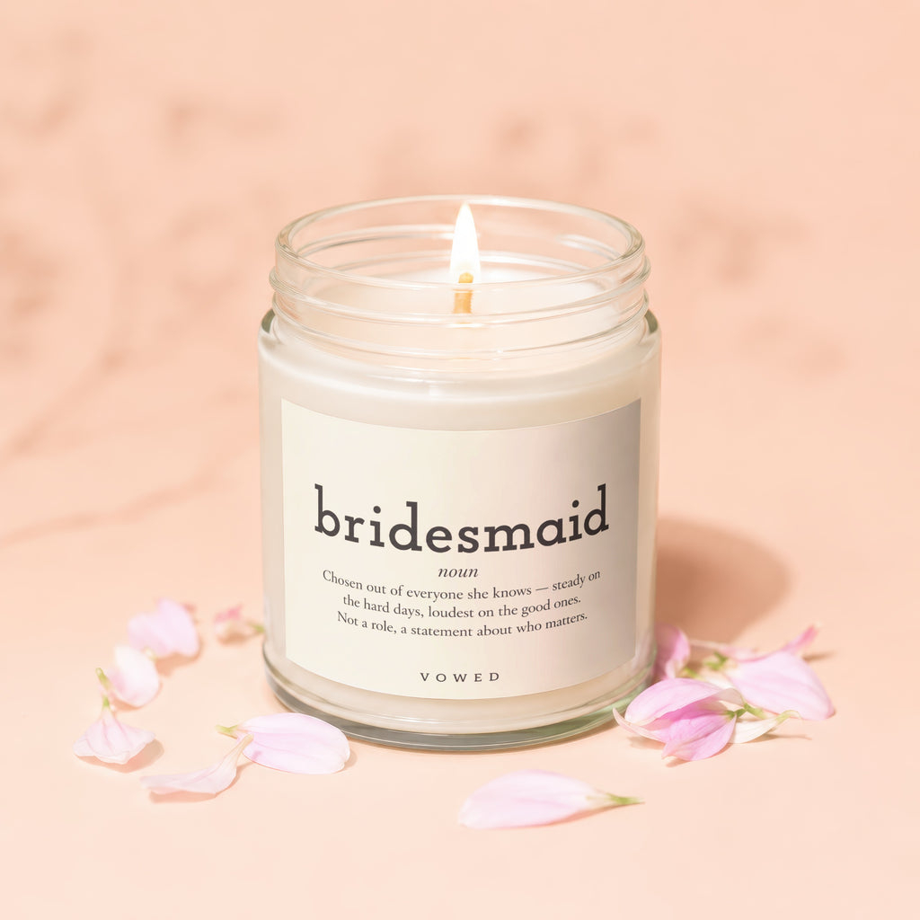 Candle with label reading "bridesmaid" and definition, surrounded by pink petals.