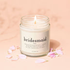 Candle with label reading "bridesmaid" and definition, surrounded by pink petals.