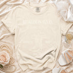 Cream Comfort Colors t-shirt with "Reckless in Texas Olivia's Bach" text and boot graphic.