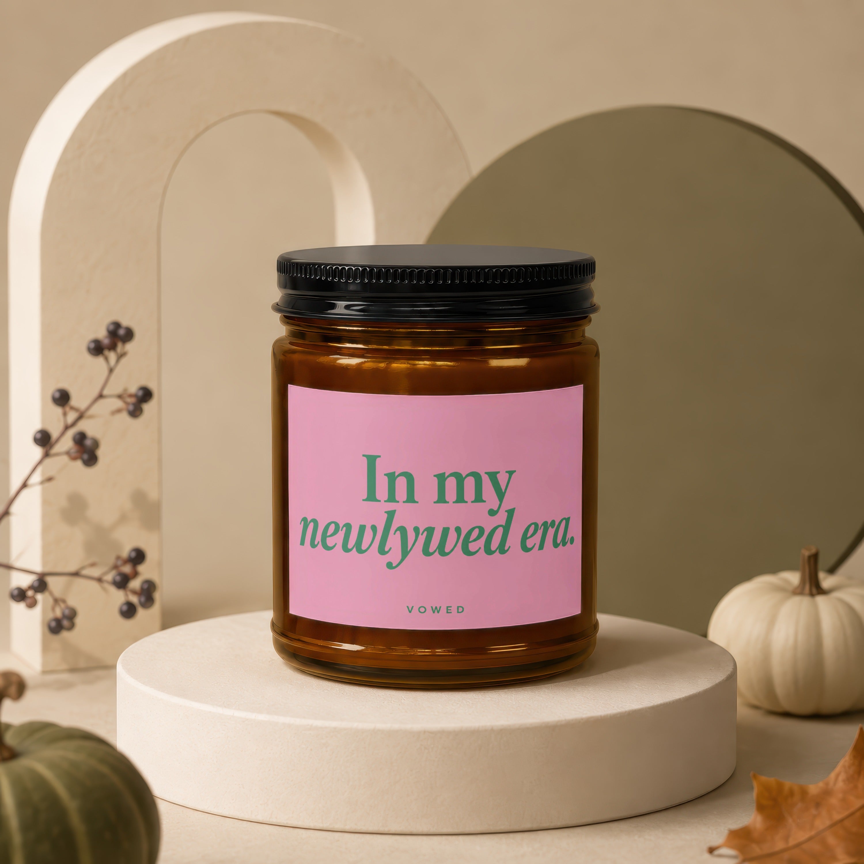 Glass candle with pink label reading "In my newlywed era. vowed".
