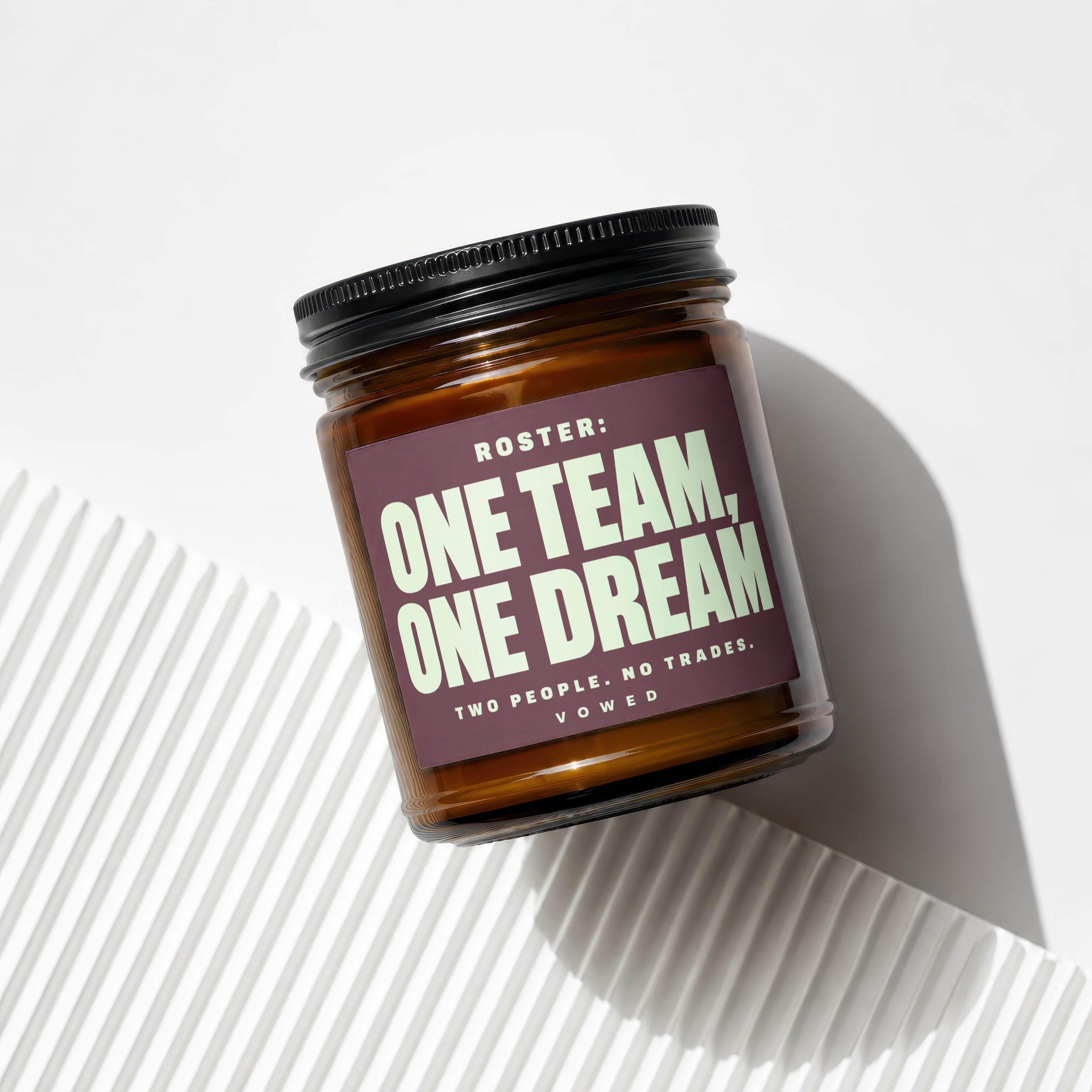 Amber glass jar with black lid, labeled "ROSTER: ONE TEAM, ONE DREAM".