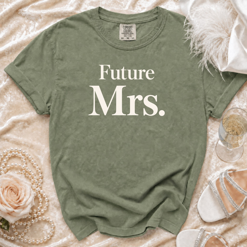 Olive green t-shirt with "Future Mrs." text, styled with pearls, a rose, and champagne.