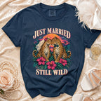 Navy t-shirt with "Just Married Still Wild" text and two leopards on a tropical sunset background.