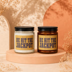 Two glass candles with black lids, labeled "HE HIT THE JACKPOT."