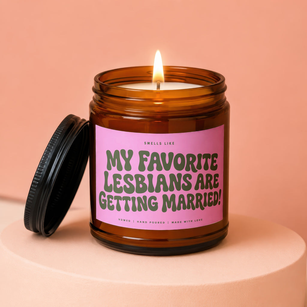 Candle with pink label reading "MY FAVORITE LESBIANS ARE GETTING MARRIED!".