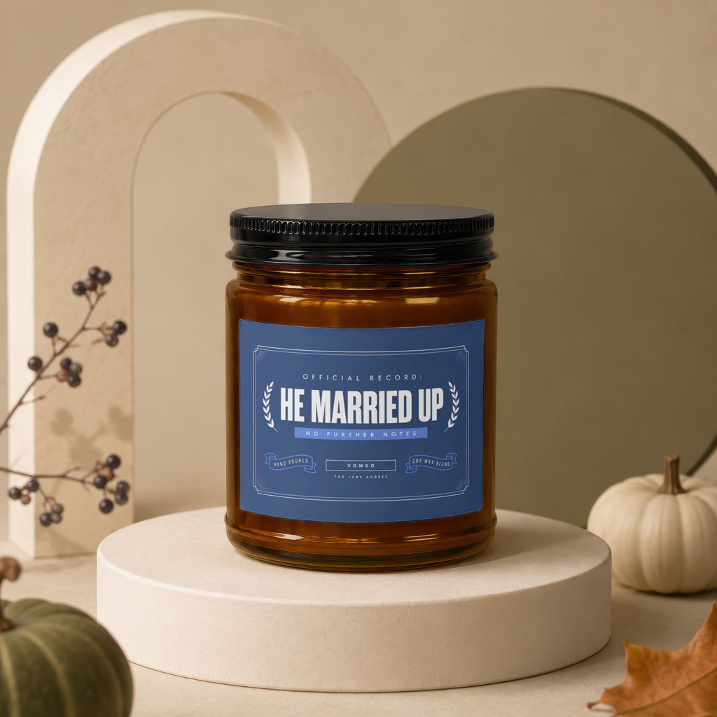 Brown glass candle with "HE MARRIED UP" label on a display pedestal.