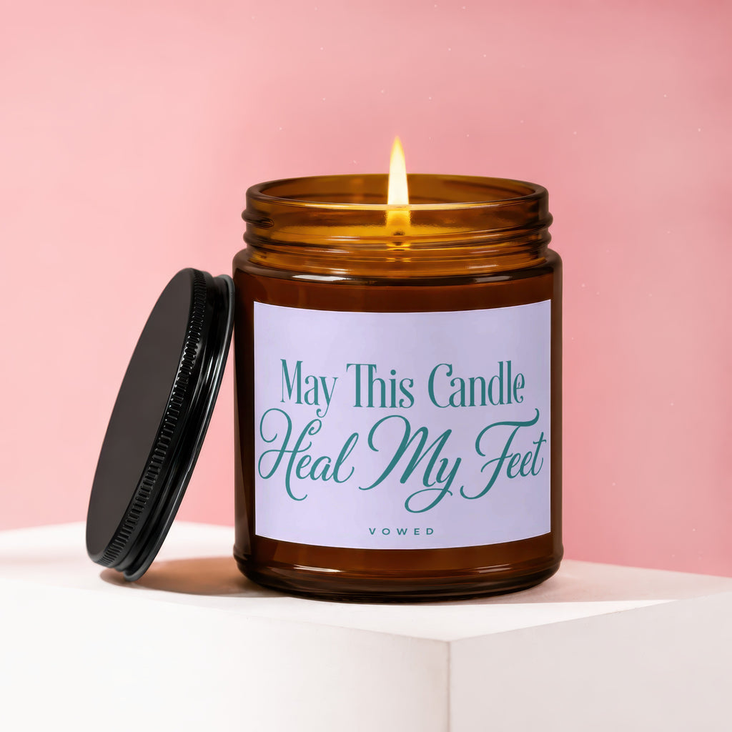 Amber jar candle with lit flame, says "May This Candle Heal My Feet".