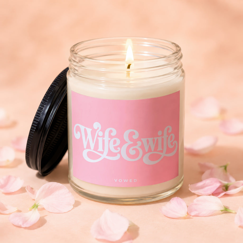 I am a candle with a pink label that says "Wife & Wife" and "VOWED".
