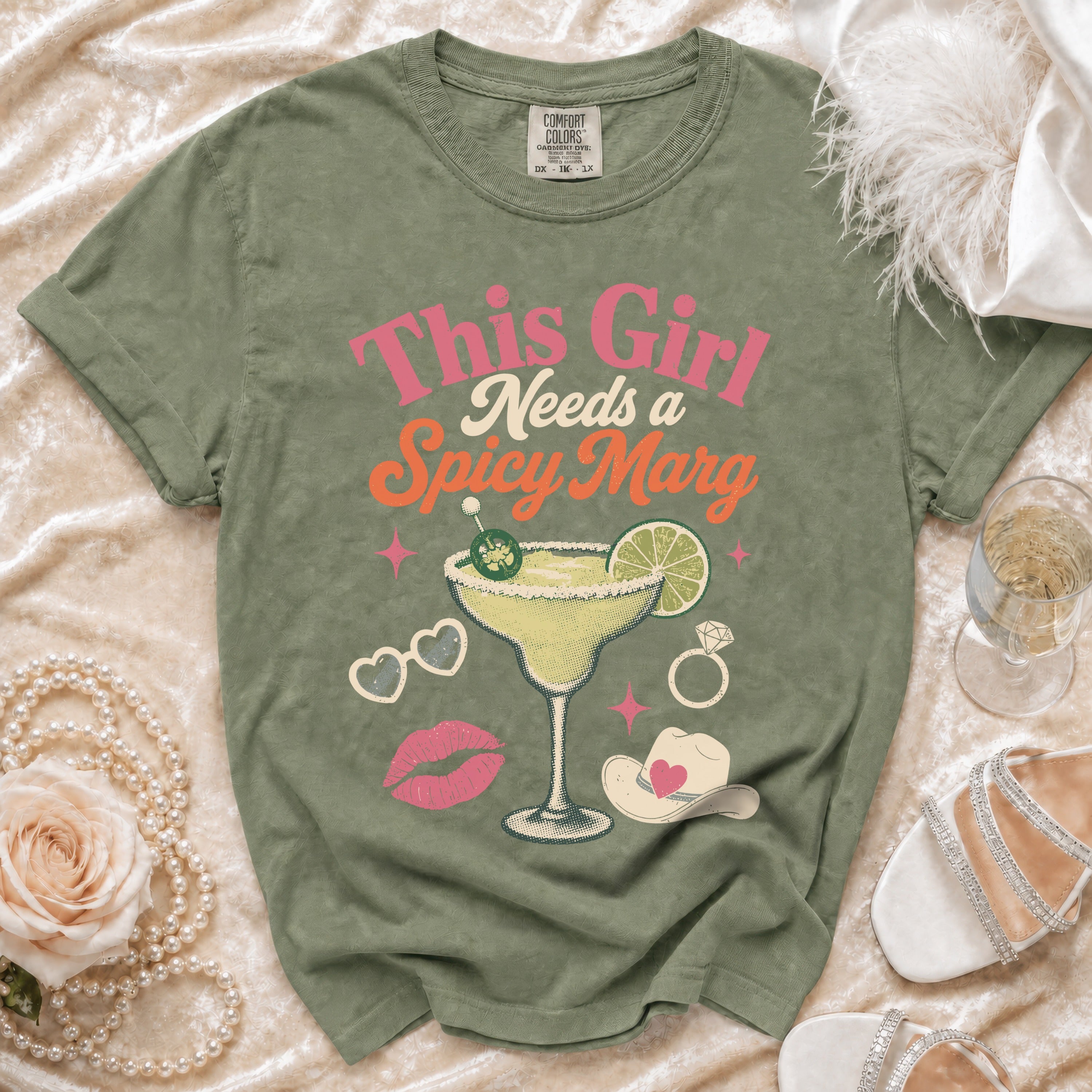 Green t-shirt with "This Girl Needs a Spicy Marg" text and margarita graphic.