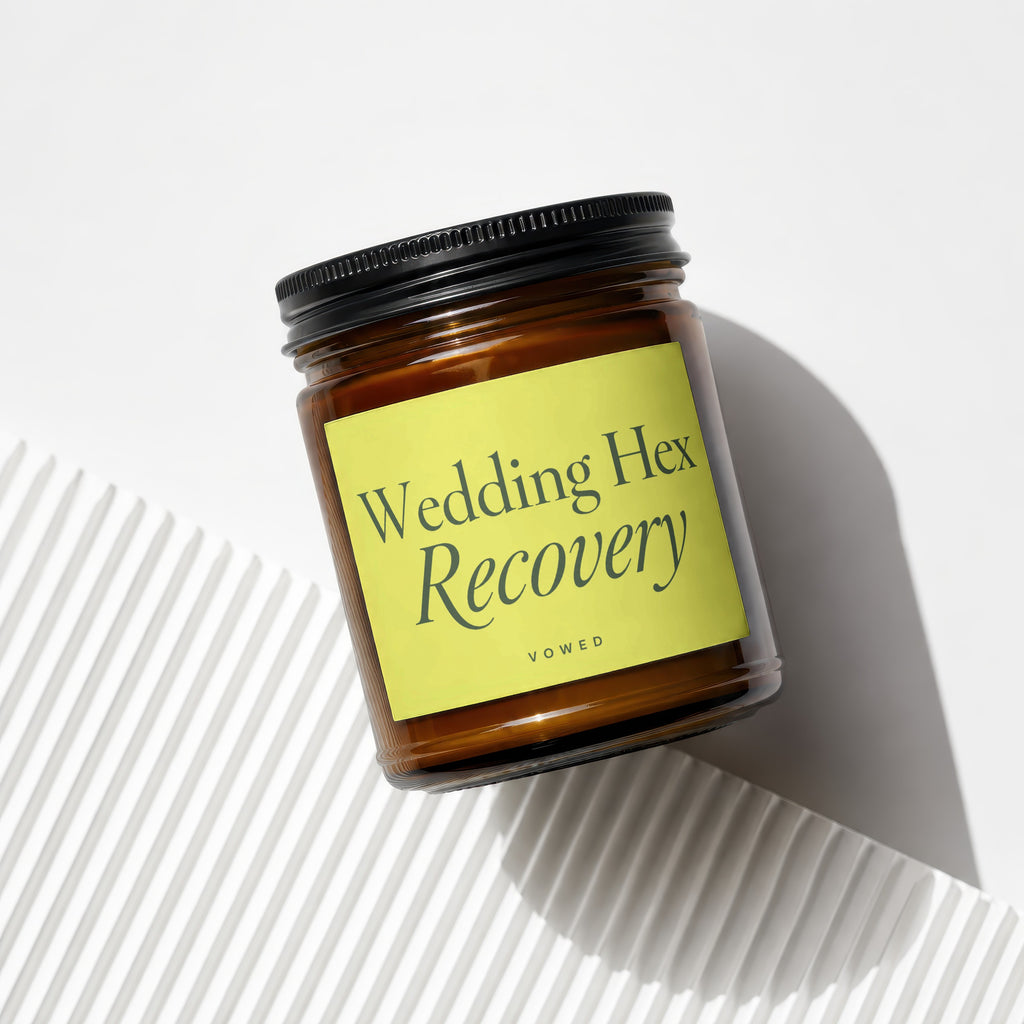 Amber candle with black lid and yellow label saying "Wedding Hex Recovery".