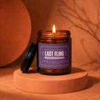 Lit amber candle labeled "Last Fling Before The Ring" on an orange podium.