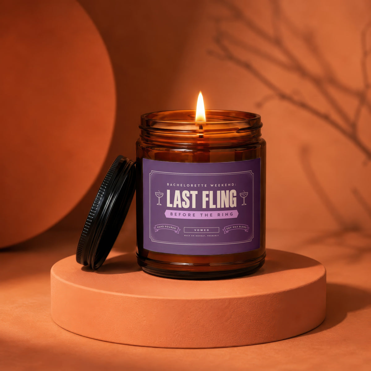 Lit amber candle labeled "Last Fling Before The Ring" on an orange podium.