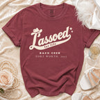 A maroon crewneck t-shirt with cream text reading Lassoed for life Bach Crew Fort Worth, 2027.