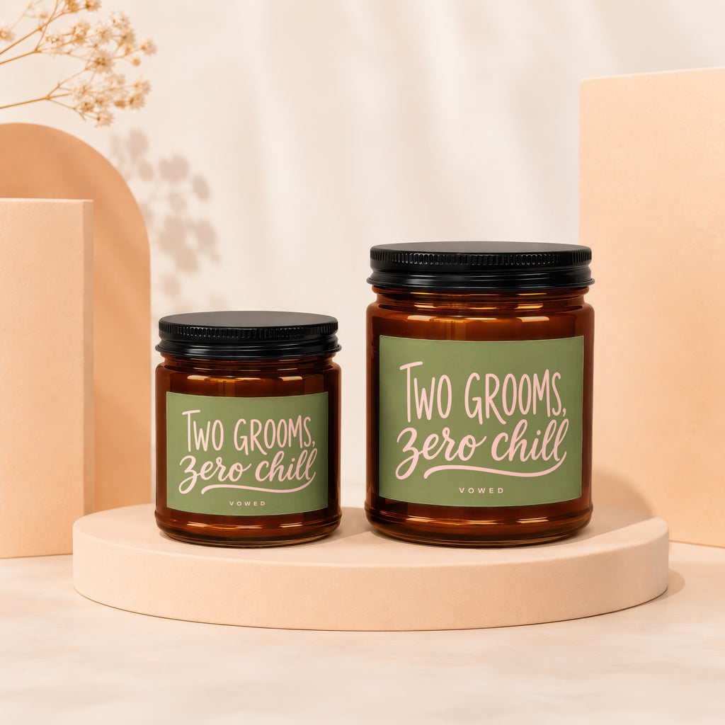 Two amber jar candles reading "Two Grooms, Zero Chill" in pastel pink text.