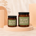 Two amber jar candles reading "Two Grooms, Zero Chill" in pastel pink text.
